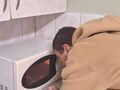 Chłopiec patrzy przez okienko w mikrofalówce
