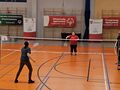 5 zawodniczki grają mecz badmintona obok siędzia