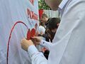 Uczeń przyczepia czerwone serce wdzięczności na banerze