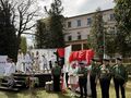 Uczniowie wysępujący podczas akademii schodzą ze sceny obok harcerzy przy drogowskazie