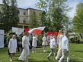 Uczniowie z nauczycielkami tańczą przed sceną do piosenki patriotycznej