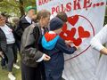 Uczniowie z wychowawcami przyczepiają czerwone serca wdzięczności na białym tle
