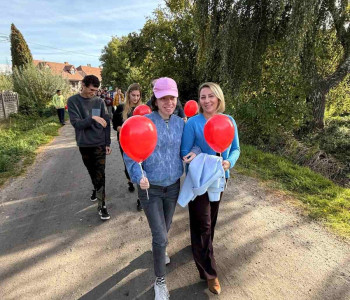 uczennica spaceruje z wychowawcą i niesie czerwony balon