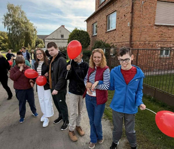 uczniowie wraz z nauczycielkami podczas marszu przedstawiają czerwone balony